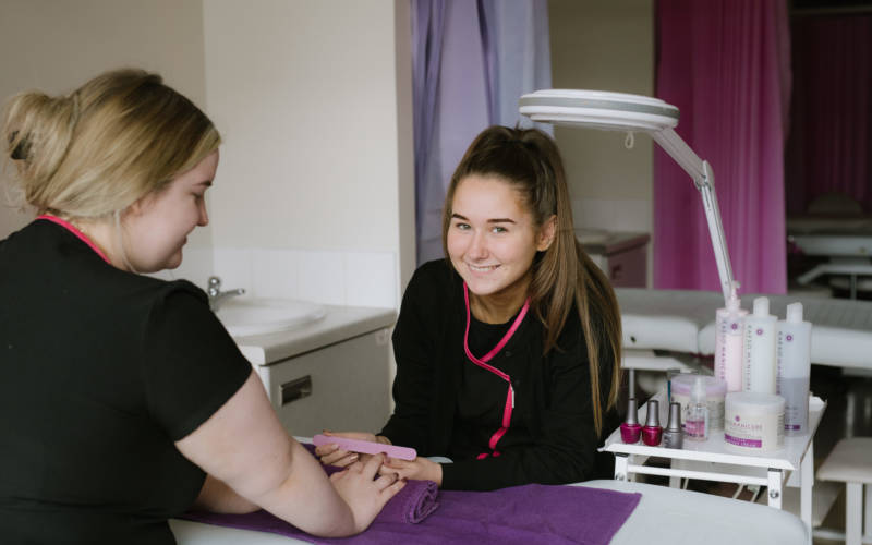 Beauty Therapy student practising manicure on fellow student in college salon