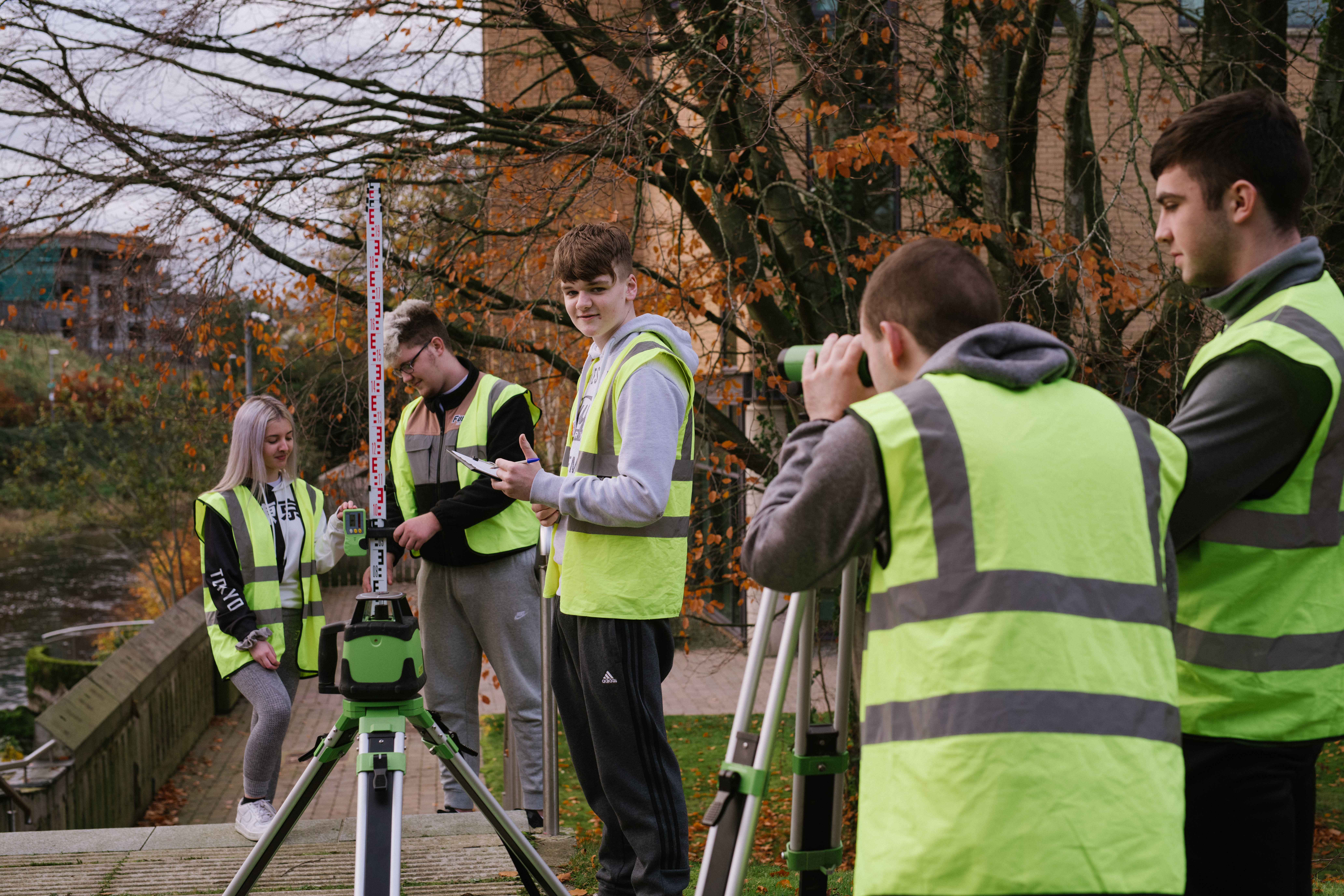 Group of construction students working outdoors wearing hi-vis jackets