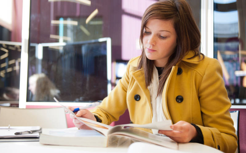 Female SWC student reading in bright modern campus library